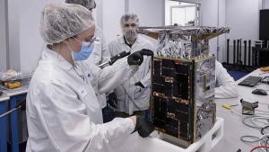 Rebecca Rogers, systems engineer, left, takes dimension measurements of the CAPSTONE spacecraft in April 2022, at Tyvak Nano-Satellite Systems, Inc., in Irvine, Calif. NASA said Tuesday, July 5, that it has lost contact with a $32.7 million spacecraft headed to moon to test out a lopsided lunar orbit, but agency engineers are hopeful they can fix the problem. (Dominic Hart/NASA via AP)