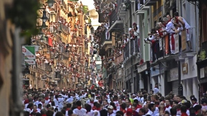 People run through the streets ahead of fighting bulls and steers during the first day of the running of the bulls at the San Fermin Festival in Pamplona, northern Spain, Thursday, July 7, 2022. Revelers from around the world flock to Pamplona every year for nine days of uninterrupted partying in Pamplona's famed running of the bulls festival which was suspended for the past two years because of the coronavirus pandemic. (AP Photo/Alvaro Barrientos)