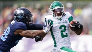 Saskatchewan Roughriders' Mario Alford, right, avoids a tackle by Toronto Argonauts' Wynton McManis during the first half of CFL action at Acadia University in Wolfville, N.S., Saturday, July 16, 2022. THE CANADIAN PRESS/Darren Calabrese