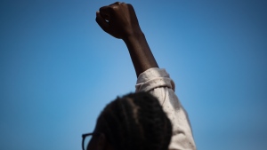 FILE - A person raises their fist in the air while attending a rally before an Emancipation Day March, in Vancouver, on Saturday, August 1, 2020. Emancipation Day marks the abolition of slavery in parts of the British Empire. The Slavery Abolition Act went into effect on August 1, 1834, after receiving Royal Assent nearly a year earlier. THE CANADIAN PRESS/Darryl Dyck 
