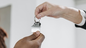 In this stock photo, a homebuyer and seller are seen exchanging house keys after a purchase. (Pavel Danilyuk / Pexels.com)