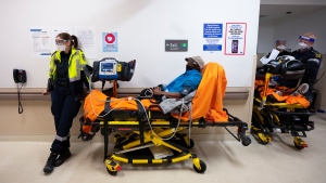 Paramedics transfer patients to the emergency room triage but have no choice but to leave them in the hallway due to an at capacity emergency room at the Humber River Hospital during the COVID-19 pandemic in Toronto on Tuesday, January 25, 2022. THE CANADIAN PRESS/Nathan Denette 