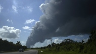 A huge plume of smoke rises from the Matanzas Supertanker Base, caused by a blaze which began during a thunderstorm the night before, in Matazanas, Cuba, Saturday, Aug. 6, 2022. Cuban authorities say lightning struck a crude oil storage tank at the base, causing a fire that led to four explosions which injured more than 50 people. (AP Photo/Ramon Espinosa)