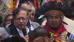 President-elect Gustavo Petro, left, speaks to supporters during a 'popular and spiritual' inauguration ceremony presided over by local Indigenous groups and feminist activists, in Bogota, Colombia, Saturday, Aug. 6, 2022. (AP Photo/Ariana Cubillos)