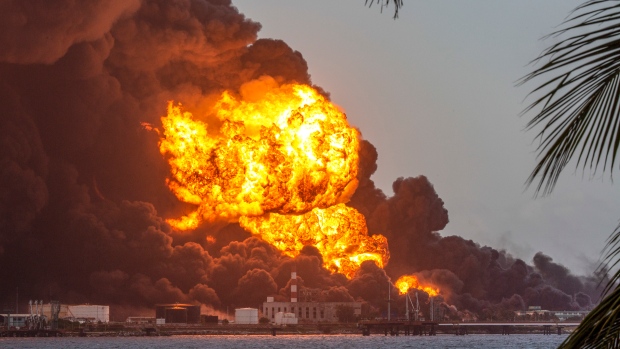 Flames and smoke rise from the Matanzas Supertanker Base as firefighters work to quell the blaze which began during a thunderstorm in Matanzas, Cuba, Monday, Aug. 8, 2022. Cuban authorities say lightning struck a crude oil storage tank at the base, sparking a fire that sparked four explosions. (AP Photo/Ismael Francisco)
