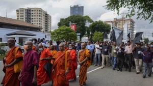 Trade union and civil society activists led by leftists' People Liberation Front shout slogans denouncing president Ranil Wickremesinghe as they march in streets in Colombo, Sri Lanka, Tuesday, Aug. 9, 2022. Hundreds of Sri Lankans Tuesday rallied against a government crackdown and the use of emergency laws against those who protested peacefully against the country’s worst economic crisis in recent memory. (AP Photo/Eranga Jayawardena)