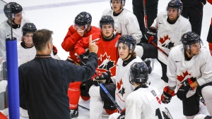 Canada’s National Junior Team assistant coach Michael Dyck, left, gives instructions during a training camp practice in Calgary, Tuesday, Aug. 2, 2022.THE CANADIAN PRESS/Jeff McIntosh