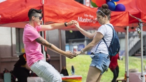 Florence, left, and Billie dance at the site where the Montreal Pride parade was supposed to start from, in Montreal, Sunday, Aug. 7, 2022. CANADIAN PRESS/Graham Hughes