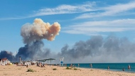 Rising smoke can be seen from the beach at Saky after explosions were heard from the direction of a Russian military airbase near Novofedorivka, Crimea, Tuesday Aug. 9, 2022. The explosion of munitions caused a fire at a military air base in Russian-annexed Crimea Tuesday but no casualties or damage to stationed warplanes, Russia's Defense Ministry said. (UGC via AP)