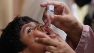 FILE - A health worker gives a polio vaccine to a child in Karachi, Pakistan, May 23, 2022. (AP Photo/Fareed Khan, file)