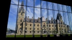 The West Block of Parliament Hill is pictured through the window of the Sir John A Macdonald building in Ottawa on Wednesday, May 11, 2022. Hundreds of scientists and researchers are expected to gather on Parliament Hill today to call for a raise. THE CANADIAN PRESS/Sean Kilpatrick