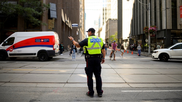 Police direct traffic in Downtown Toronto after a power outage affected traffic lights, on Thursday, August 11, 2022. THE CANADIAN PRESS/Christopher Katsarov