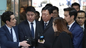 FILE - Lotte group Chairman Shin Dong-bin, center, is questioned by reporters upon arrival for his corruption trial at Seoul Central District Court in Seoul, South Korea, Dec. 22, 2017. South Korea's president will formally pardon Samsung heir Lee Jae-yong, one year after he was released on parole from a prison sentence for bribing former President Park Geun-hye as part of the massive corruption scandal that toppled Park's government, the justice minister announced Friday, Aug. 12, 2022. Shin and two other top business leaders will be pardoned as well, extending South Korea’s history of leniency toward convicted business tycoons and major white-collar crimes. (AP Photo/Lee Jin-man, File)