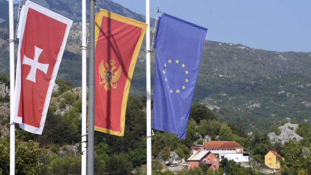 Flags flew at half-mast in front of the site of the attack in Cetinje, some 30 km west of Podgorica, Montenegro, Saturday, Aug. 13, 2022. A man went on a shooting rampage in the streets of a western Montenegro city Friday, killing multiple people, before being shot dead by a passerby, officials said. (AP Photo/Risto Bozovic)