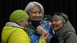 A woman glances up at Governor General Mary Simon after taking a photo together following a community gathering Tuesday, May 10, 2022 in Kangiqsualujjuaq, Que. THE CANADIAN PRESS/Adrian Wyld