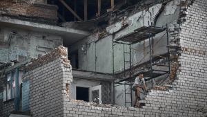 A man looks out from an apartment destroyed after Russian shelling in Nikopol, Ukraine, Monday, Aug. 15, 2022. (AP Photo/Kostiantyn Liberov)