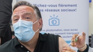 Quebec Premier François Legault receives a COVID-19 booster vaccine dose from Kenza Kias in Montreal on Aug. 5, 2022. THE CANADIAN PRESS/Graham Hughes
