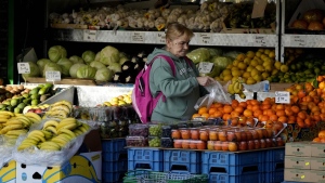 FILE - A woman selects fruits at a supermarket in London, Wednesday, Nov. 17, 2021. The Office for National Statistics said Wednesday, Aug. 17, 2022, that consumer prices inflation hit double digits, a jump from 9.4% in June and higher than analysts’ central forecast of 9.8%. The increase was largely due to rising prices for food and staples including toilet paper and toothbrushes, it said. (AP Photo/Frank Augstein, File)