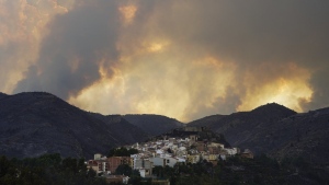 Clouds of smoke cover the sky during a wildfire near Bejis, eastern Spain, on Wednesday, Aug. 17, 2022. The European Forest Fire Information System says 275,000 hectares (679,000 acres) have burned in wildfires so far this year in Spain. That's more than four times the country's annual average of 67,000 hectares (165,000 acres) since 2006, when records began. (AP Photo/Alberto Saiz)