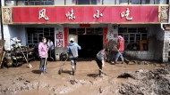 In this photo released by Xinhua News Agency, residents clear sludge from their property in the aftermath of floods in Qingshan Township of Datong Hui and Tu Autonomous County in northwest China's Qinghai Province on Thursday, Aug. 18, 2022. A sudden rainstorm in western China triggered a landslide that diverted a river and caused flash flooding in populated areas, killing some and leaving others missing, Chinese state media said Thursday. (Zhang Hongxiang/Xinhua via AP)