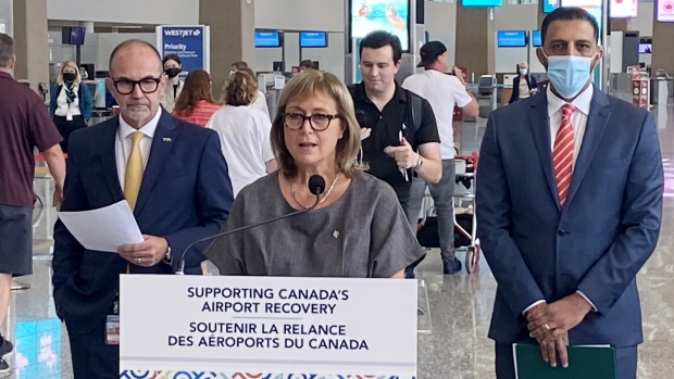 Parliamentary Secretary for Transport and Liberal MP Annie Koutrakis, centre, speaks as Calgary Airport Authority CEO Bob Sartor, left, and Liberal MP George Chahal look on during a funding announcement in Calgary on Aug. 23, 2022. THE CANADIAN PRESS/Bill Graveland