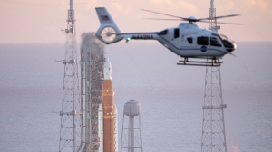 A NASA helicopter flies past the agency's Space Launch System (SLS) rocket with the Orion spacecraft atop the mobile launcher at Launch Pad 39B, Monday, Aug. 29, 2022, in Cape Canaveral, Fla. The launch was scrubbed. (Joel Kowsky/NASA via AP)