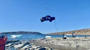 A helicopter airlifts a Ford F-150 into the air to transport it from near the Tasmania Islands to Gjoa Haven, Nvt., in a handout photo. An international team has completed the massive operation to recover the truck from remote Arctic waters. THE CANADIAN PRESS/HO-TransGlobal Car Expedition