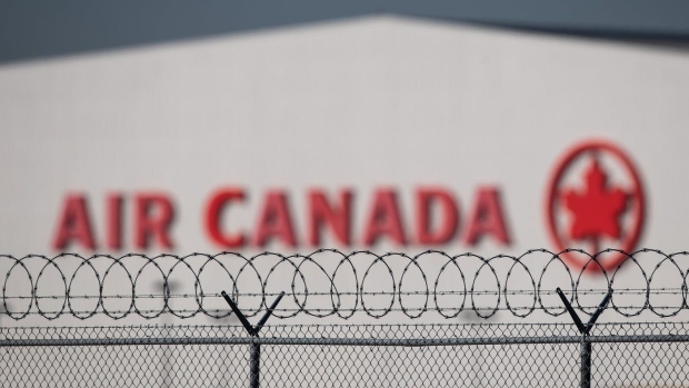 An Air Canada hangar is seen behind a security fence at Vancouver International Airport, in Richmond, B.C., on Friday, March 20, 2020. Air Canada has signed a deal to buy 30 electric-hybrid aircraft under development by Swedish company Heart Aerospace.THE CANADIAN PRESS/Darryl Dyck