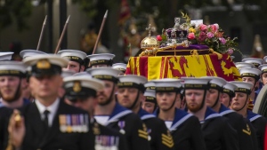 The coffin of Queen Elizabeth II is pulled on a gun carriage through the streets of London following her funeral service at Westminster Abbey, Monday Sept. 19, 2022.The Queen, who died aged 96 on Sept. 8, will be buried at Windsor alongside her late husband, Prince Philip, who died last year. (AP Photo/Emilio Morenatti,Pool)
