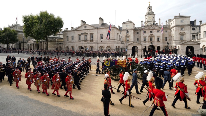 The coffin of Queen Elizabeth II is pulled past Horse Guards Avenue following her funeral service in Westminster Abbey in central London Monday Sept. 19, 2022. The Queen, who died aged 96 on Sept. 8, will be buried at Windsor alongside her late husband, Prince Philip, who died last year. (David Davies/Pool Photo via AP)