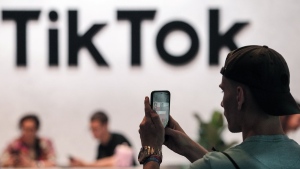 A visitor makes a photo at the TikTok exhibition stands at the Gamescom computer gaming fair in Cologne, Germany, Thursday, Aug. 25, 2022. Online streaming giants YouTube and TikTok are asking Canadian senators to take a sober second look at an online streaming bill that they say would cause significant harm Canadian digital creators. THE CANADIAN PRESS/AP, Martin Meissner