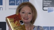 FILE - Hilary Mantel, winner of the Man Booker Prize for Fiction, poses with a copy of her book 'Bring up the Bodies', shortly after the award ceremony in central London, on Oct. 16, 2012. Mantel, the Booker Prize-winning author of the acclaimed “Wolf Hall” saga, has died, publisher HarperCollins said Friday Sept. 23, 2022. She was 70. (AP Photo/Lefteris Pitarakis, File)