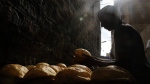 A baker stacks loaves of Egyptian traditional "baladi" flatbread outside a bakery, in the Old Cairo district of Cairo, Egypt, Sept. 8, 2022. For decades, millions of Egyptians have depended on the government to keep basic goods affordable. But a series of shocks to the global economy and Russia's invasion of Ukraine have endangered the social contract in the Middle East's most populous country, which is also the world's biggest importer of wheat. It is now grappling with double-digit inflation and a steep devaluation of its currency. (AP Photo/Amr Nabil)