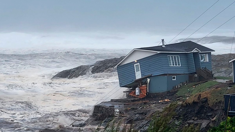 In this photo provided by Wreckhouse Press a home fights against high winds caused by post Tropical Storm Fiona in Port aux Basques, Newfoundland and Labrador, Saturday, Sept. 24, 2022. The home has since been lost at sea. (Rene Roy/Wreckhouse Press via The Canadian Press via AP)