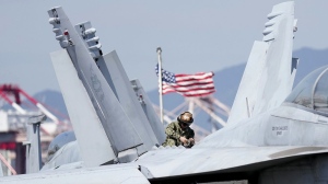 U.S. soldier checks the F/A-18 Super Hornet fighter jet on the deck of the nuclear-powered aircraft carrier USS Ronald Reagan in Busan, South Korea, Friday, Sept. 23, 2022. The nuclear-powered aircraft carrier USS Ronald Reagan arrived in the South Korean port of Busan on Friday ahead of the two countries' joint military exercise that aims to show their strength against growing North Korean threats. (AP Photo/Lee Jin-man)