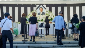 People leave flowers and pay their respects to former Japanese Prime Minister Shinzo Abe outside the Nippon Budokan in Tokyo Tuesday, Sept. 27, 2022, ahead of his state funeral later in the day. (Nicolas Datiche/Pool Photo via AP)
