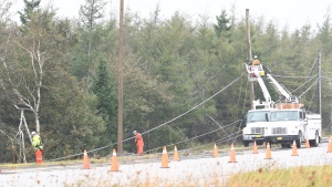 Nova Scotia Power crews work to repair toppled power lines in front of the entrance to the McCurdy Airport in Sydney, N.S., Monday, Sept. 26, 2022. THE CANADIAN PRESS/Vaughan Merchant