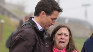 Prime Minister Justin Trudeau comforts resident Amy Osmond during his visit to Port aux Basques, N.L. on Wednesday, Sept. 28, 2022. Residents of southwestern Newfoundland continued Wednesday to dig though the rubble of their former homes after post-tropical storm Fiona. THE CANADIAN PRESS/Frank Gunn 