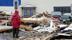 A Canadian Forces Ranger examines damage to a home in Port aux Basques, N.L., Monday, Sept. 26, 2022. More than 75 homes in the town of 4,000 people were destroyed or severely damaged, Newfoundland MP Gudie Hutchings said earlier this week. THE CANADIAN PRESS/Frank Gunn
