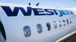 A WestJet planes waits at a gate at Calgary International Airport in Calgary, Alta., Wednesday, Aug. 31, 2022. WestJet has announced an agreement with Boeing to purchase 42 737-10 MAX aircraft to extend the fleet with growth plans to 2028. THE CANADIAN PRESS/Jeff McIntosh