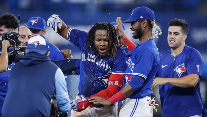 Toronto Blue Jays first baseman Vladimir Guerrero Jr. (27) celebrates with teammates after hitting the game winning RBI single against the New York Yankees during tenth inning American League MLB baseball action in Toronto on Monday, September 26, 2022. THE CANADIAN PRESS/Cole Burston