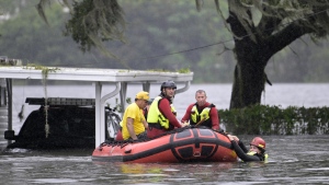 First responders with Orange County Fire Rescue use an inflatable boat to rescue a resident from a home in the aftermath of Hurricane Ian, Thursday, Sept. 29, 2022, in Orlando, Fla. (AP Photo/Phelan M. Ebenhack)