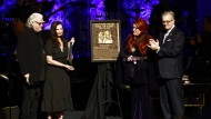FILE - Wynonna Judd, second from the right, stands next to the Judds' induction plaque as sister Ashley Judd, left, Ricky Skaggs, and MC Kyle Young, CEO of the Country Music Hall of Fame & Museum look on during the Medallion Ceremony in Nashville, Tenn., on May 1, 2022. Fans of Naomi Judd, the late matriarch of the Grammy-winning country duo, will have a chance to say goodbye and rejoice in their hits in a final tour helmed by daughter Wynonna and all-star musical partners. (Photo by Wade Payne/Invision/AP, File)