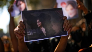 FILE - A woman holds a a photo of Iranian Mahsa Amini during a protest against her death, outside Iran's general consulate in Istanbul, Turkey, Wednesday, Sept. 21, 2022. (AP Photo/Francisco Seco) 