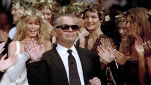 FILE - German fashion designer Karl Lagerfeld acknowledges the applause of his models at the end of the show he designed for the French fashion house Chanel, for the 1993-94 Fall-Winter haute couture collection in Paris, July 20, 1993. US Vogue Editor-in-Chief Anna Wintour convened a huddle of top Paris Fashion Week insiders Friday to announce that the theme of next year's annual Met Gala will be the work of the late Karl Lagerfeld. (AP Photo/Lionel Cironneau, File)