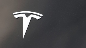 FILE - The Tesla company logo is seen on the hood of an unsold vehicle at a dealership, Sunday, Aug. 9, 2020, in Littleton, Colo. (AP Photo/David Zalubowski, File) 