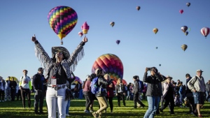 Nicole Tagart, a launch official with the 50th annual Albuquerque International Balloon Fiesta, signals a balloonist to take off in Albuquerque, N.M., on Saturday, Oct. 1, 2022. (Roberto E. Rosales/The Albuquerque Journal via AP)