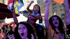 Followers of former Brazilian President Luiz Inacio "Lula" da Silva, who is running for president again, react as they listen to the partial results after general election polls closed in Rio de Janeiro, Brazil, Sunday, Oct. 2, 2022. (AP Photo/Silvia Izquierdo)