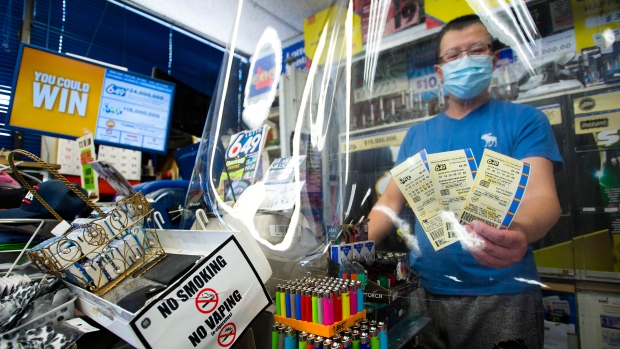 A convenience store owner shows OLG 649 and Lotto Max tickets at his store in Mississauga, Ont. THE CANADIAN PRESS/Nathan Denette