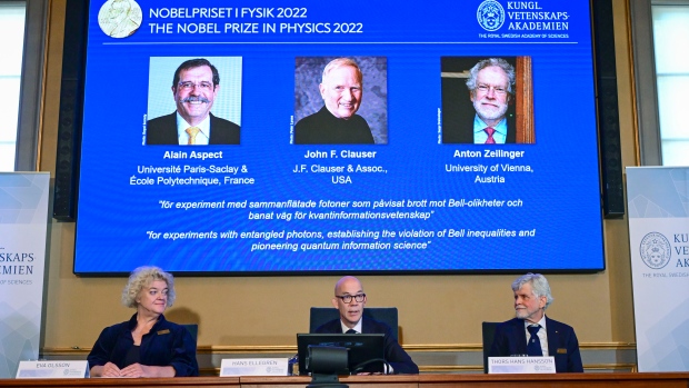 Secretary General of the Royal Swedish Academy of Sciences Hans Ellegren, centre, Eva Olsson, left and Thors Hans Hansson, members of the Nobel Committee for Physics announce the winner of the 2022 Nobel Prize in Physics, from left to right on the screen, Alain Aspect, John F. Clauser and Anton Zeilinger, during a press conference at the Royal Swedish Academy of Sciences, in Stockholm, Sweden, Tuesday, Oct. 4, 2022. (Jonas Ekstromer /TT News Agency via AP)